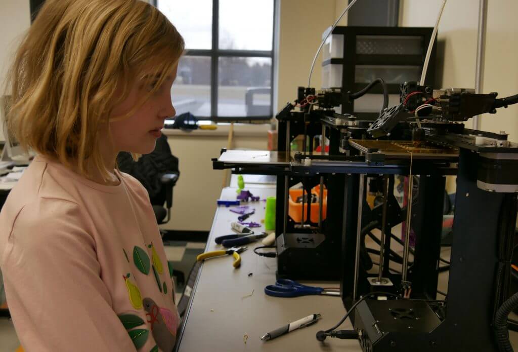 Abby Hollis watches as the 3D printer creates a horse she designed