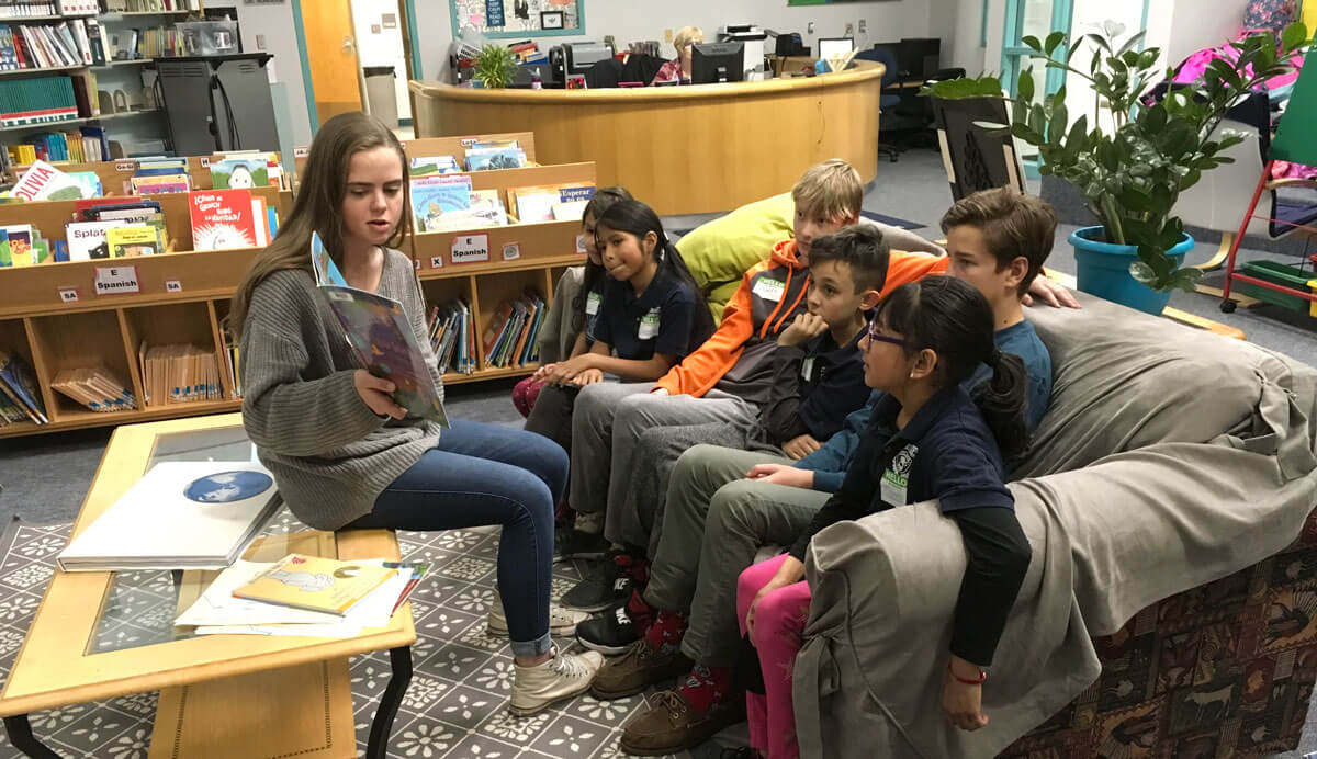 Rebecca Kerr, James Doolittle, and Grady Behrhorst used children's books to help talk about personal stories of immigration with a group of third graders at Castro Elementary School in Denver.