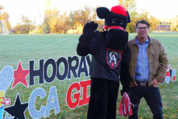 CA mascot Gus and Head of School Mike Davis wave to families on CA Gives Day, October 28, 2021.