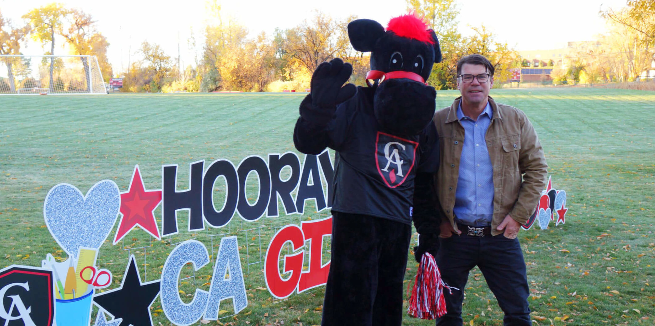 CA mascot Gus and Head of School Mike Davis wave to families on CA Gives Day, October 28, 2021.